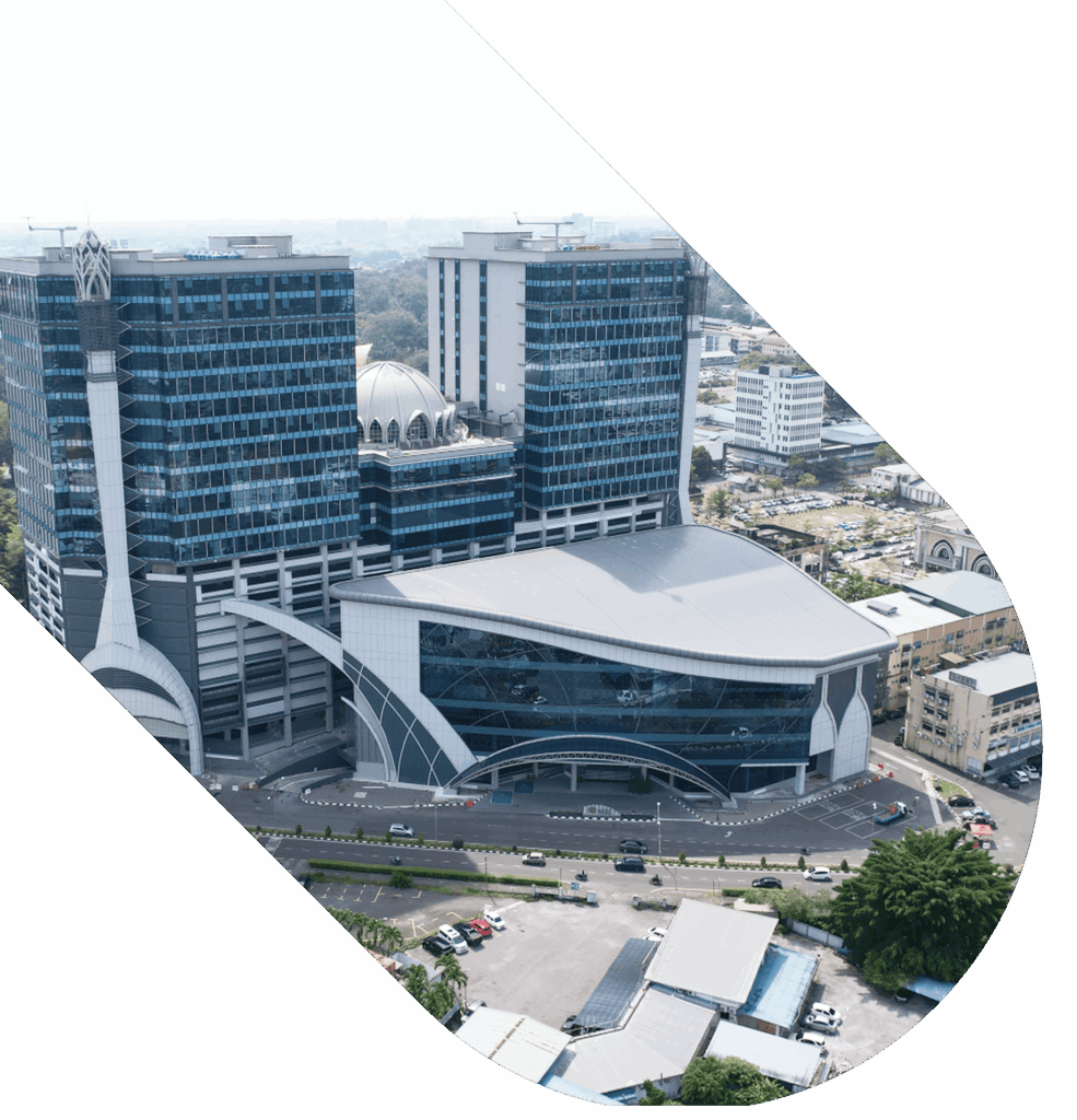 Aerial view of glass towers, mosque dome, and curved-roof building in urban setting